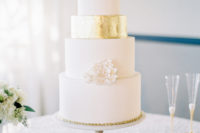 09 The wedding cake was elegant, in white and with touches of gold, with cream flowers on top
