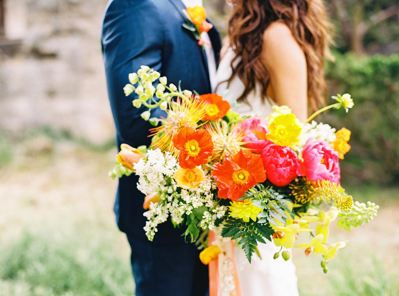 The bride was rocking a super bold bouquet in pink, yellow, red and orange