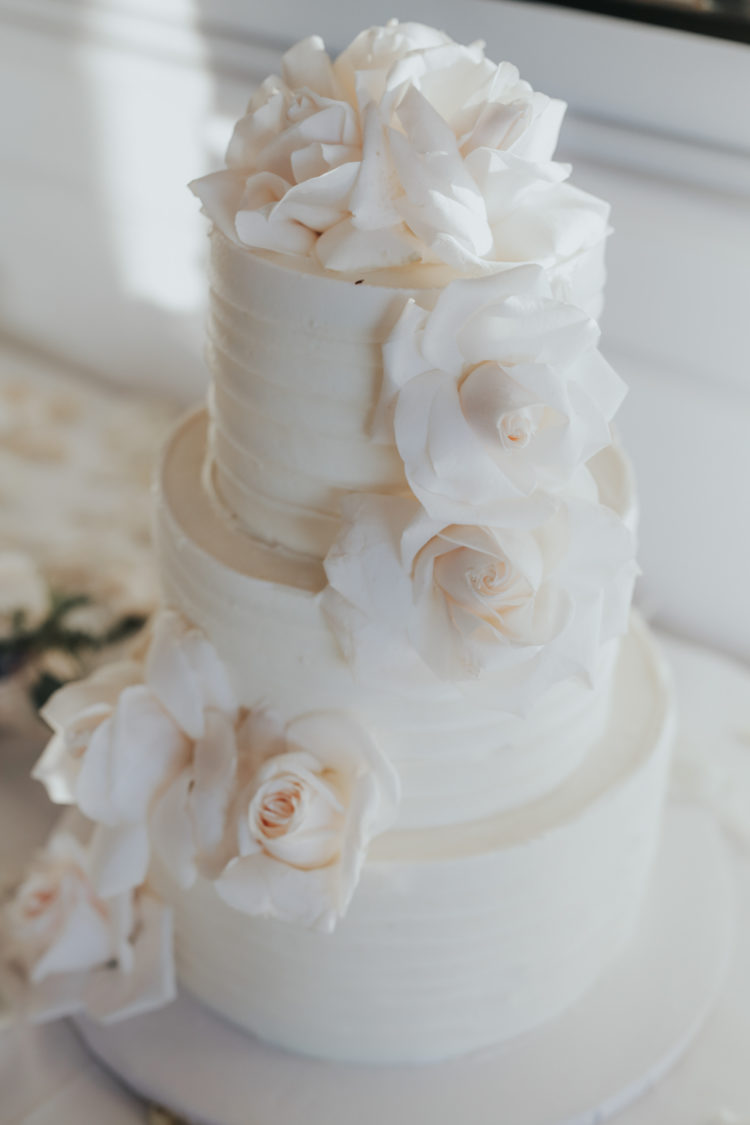 All-white wedding cake decorated with roses was a perfect fit for the wedding