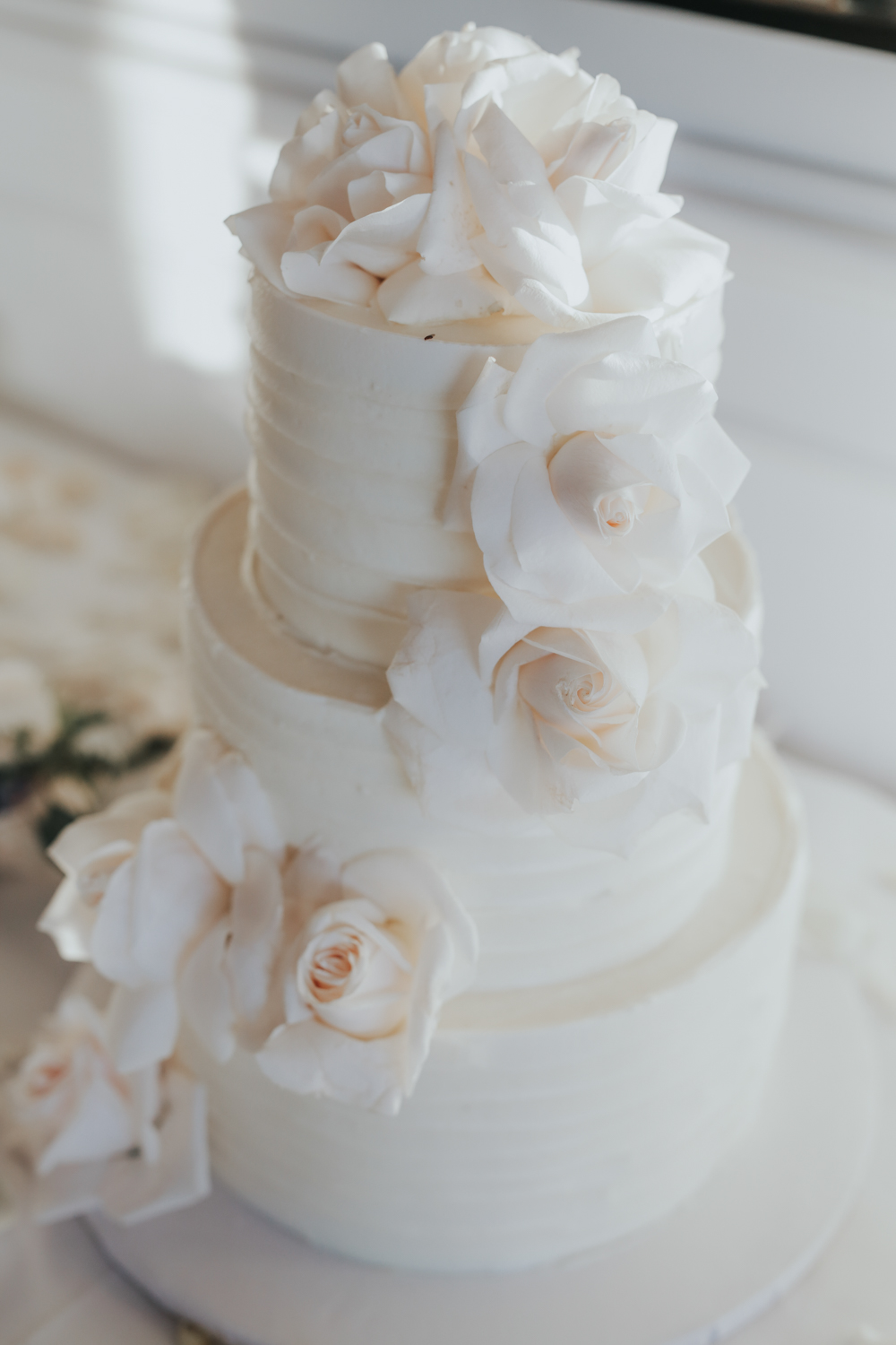 All white wedding cake decorated with roses was a perfect fit for the wedding