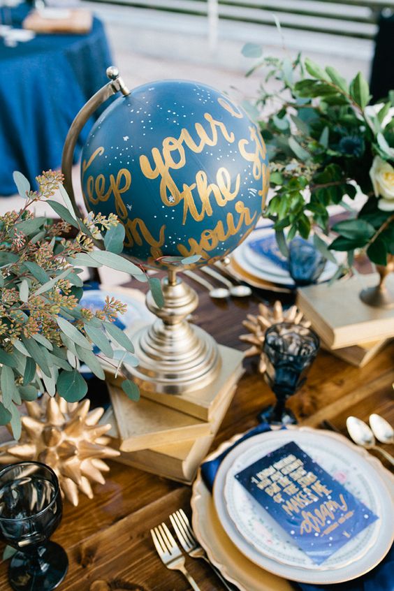 a blue and gold globe for a centerpiece and blue starry place cards