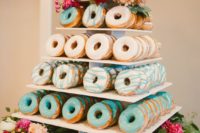 11 colorful glaze donut tower displayed with flowers and greenery