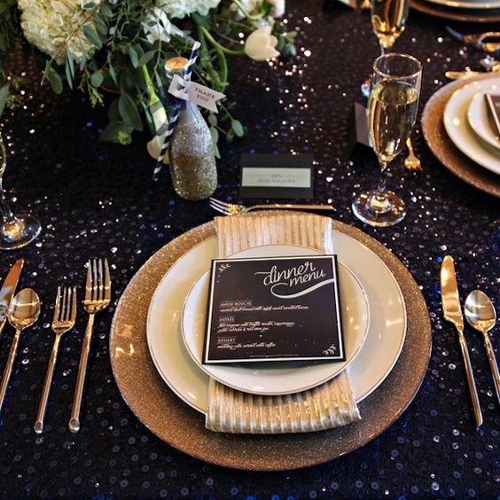 a navy sequin tablecloth and gold glitter platters and vases will sparkle like stars