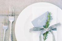 20 a minimalist table setting with a white napkin and a dusty blue velvet ribbon