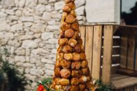 20 croquembouche with pistachio cream served on a wooden slice with fresh flowers