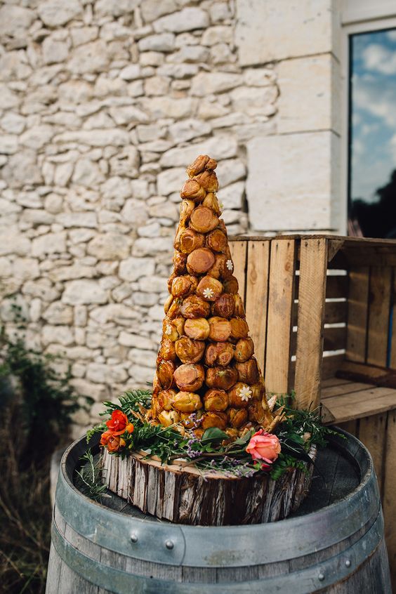 croquembouche with pistachio cream served on a wooden slice with fresh flowers