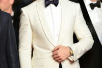 24 Ryan Gosling rocking an ivory dinner jacket and navy tuxedo pants