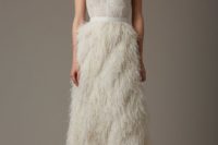 an ivory wedding dress with an illusion neckline and a one shoulder tulle part and a feather skirt is a glam and delicate solution