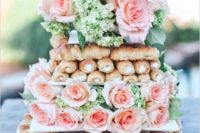 25 cannoli tower cake displayed with fresh pink roses