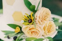 26 a hexagon wedding cake topped with honey and with fresh flowers and greenery