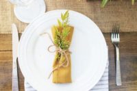26 farm table setting with a burlap table runner and a mustard napkin with twine and greenery