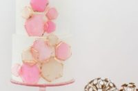 27 a wedding cake decorated with pink honeycombs with a gilded edge