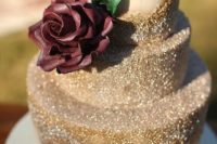 28 a gold glitter wedding cake with a cream burgundy rose