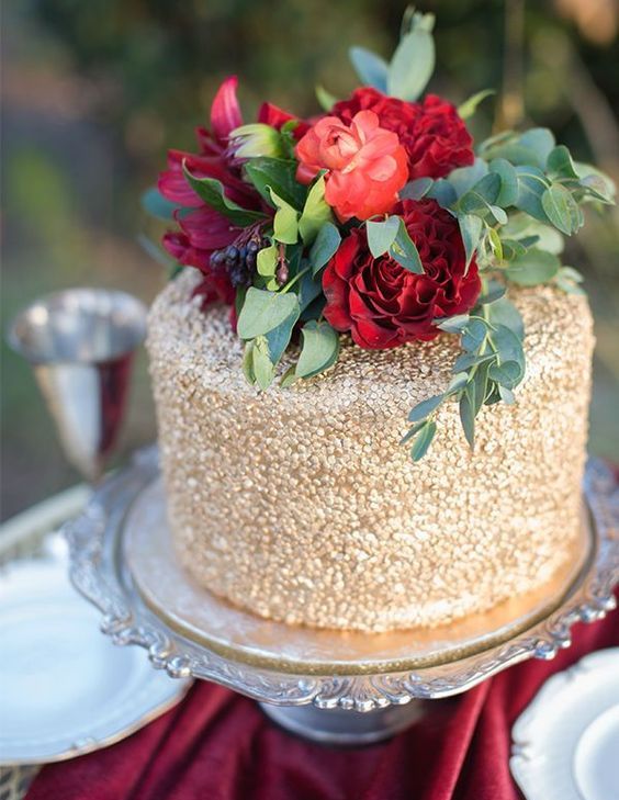 gold wedding cake with bold red roses on top