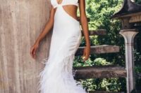 a chic modern plain wedding dress with spaghetti straps, side cutouts, a feathered skirt and pearl earrings for a sexy bridal look