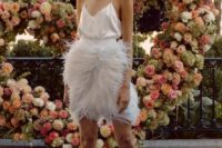 a chic reception look with a silk spaghetti strap top and a feather over the knee skirt plus statement earrings