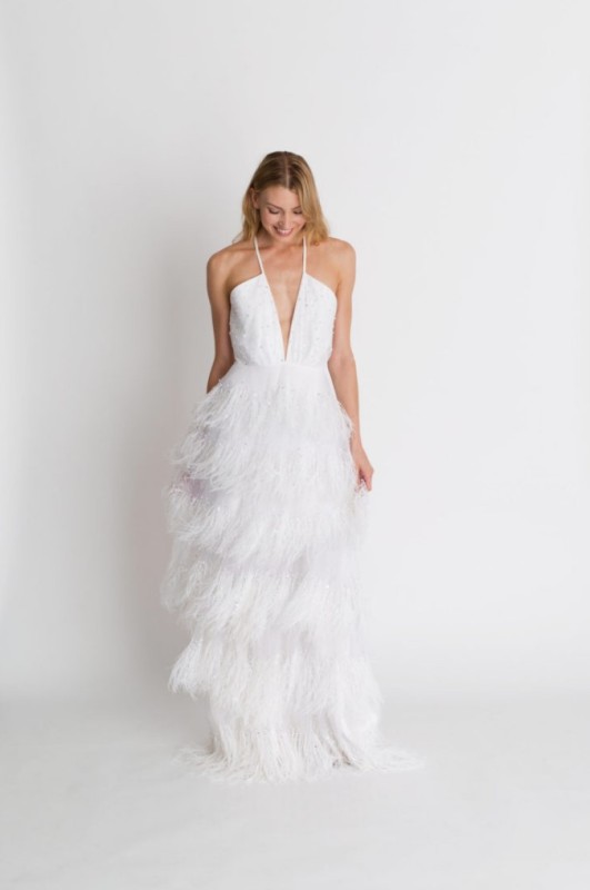 a delicate and romantic white wedding dress with an embellished plunging neckline bodice and a feather skirt