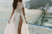 a glam bridal look with an embellished A-line wedding dress with strategically placed lace on the bodice, puff sleeves and a feather skirt with a thigh high slit