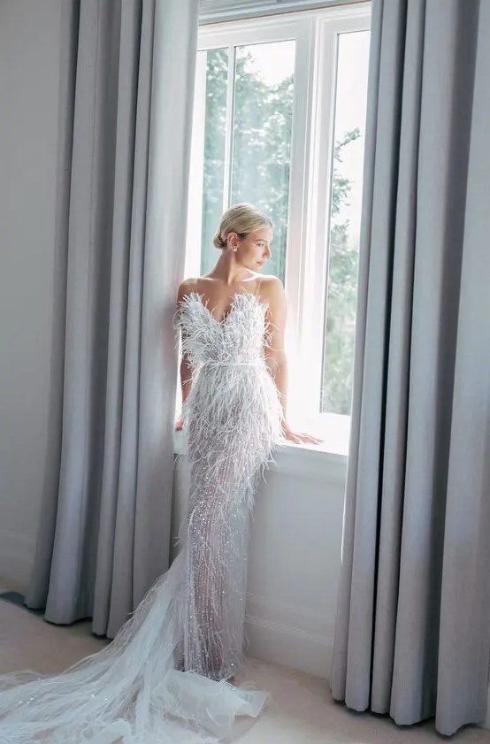 a jaw-dropping feather embellished wedding dress with a sweetheart neckline and a train is amazing for an art deco bride