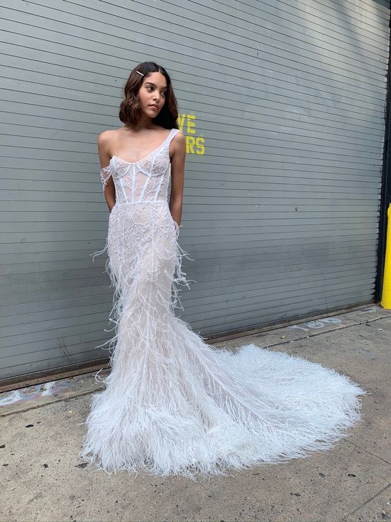 A jaw droppingly sexy feather mermaid wedding dress with thick straps and a train is a gorgeous solution for a modern bride