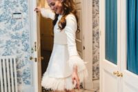 a plain A-line wedding dress with a high neckline, long feathered sleeves and a feathered skirt plus silver platform shoes