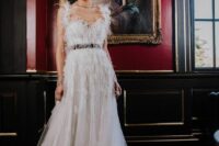 a sophisticated A-line wedding dress with a feathered bodice and straps, a V-neckline and a tulle skirt with a train is wow