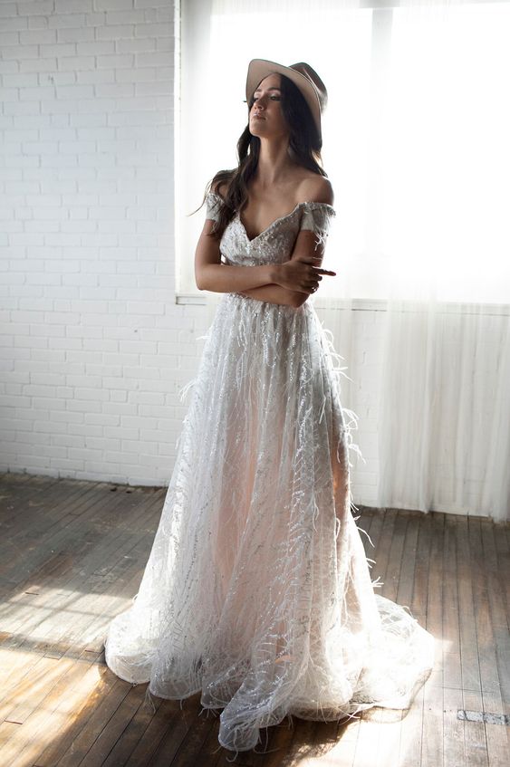 a sparkling off the shoulder feather wedding dress with a V-neckline and a train is a gorgeous idea for a glam bride