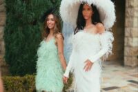 a strapless feather wedding dress with a train and long sleeves plus a crazy oversized feathered hat are wow