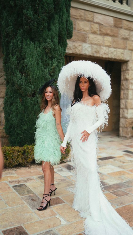 a strapless feather wedding dress with a train and long sleeves plus a crazy oversized feathered hat are wow