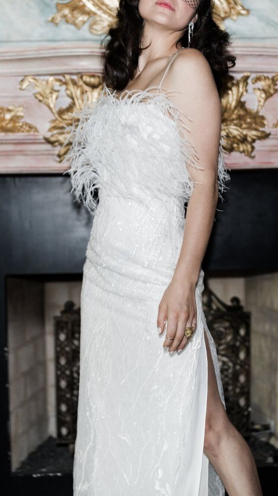 a super glam and chic neutral wedding dress with a feathered bodice and spaghetti straps plus a side slit is adorable