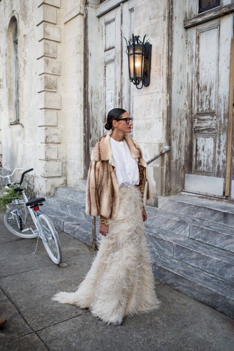a white t-shirt, a neutral feather maxi skirt with a train and a faux fur coat compose a chic and bold modern bridal look