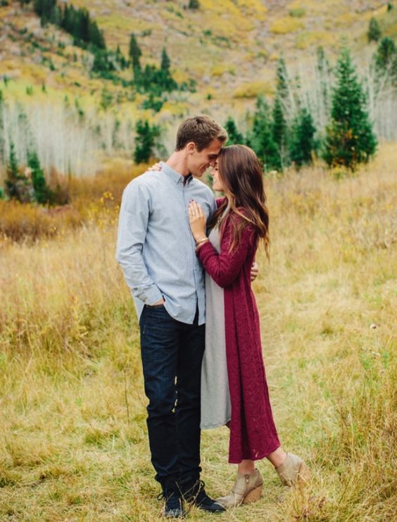 the bride-to-be is wearing a grey midi dress and a long plum-colored cardigan and greey booties to embrace the fall