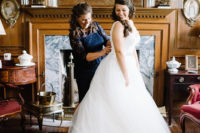 The bride was wearing a beautiful A-line gown with a cutout back, aV-neckline and a layered tulle skirt