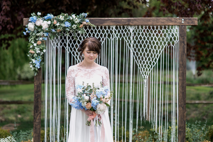 There were macrame touches used for wedding decor, and the wedding arch was one of them, it looked pretty with blue florals and macrame hangings