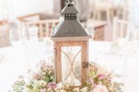 03 a metal candle lantern on a lush wildflower-style floral arrangement
