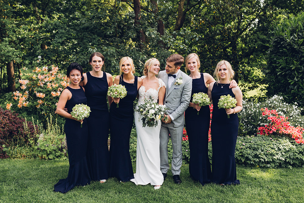 The bridesmaids were wearing navy halter neckline dresses and were carrying green bouquets