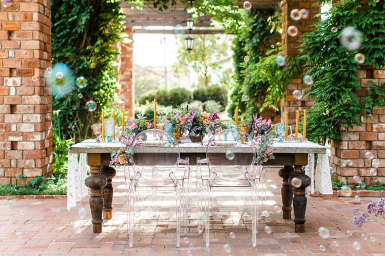 The wedding tablescape was done with lace table runners and lucite chairs