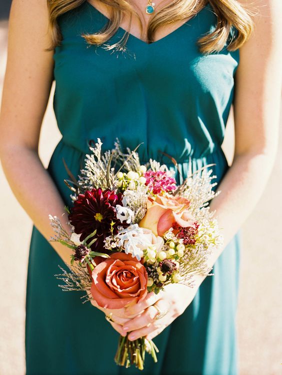 a teal bridesmaid's dress and necklace, a bouquet with copper blooms remind of the fall