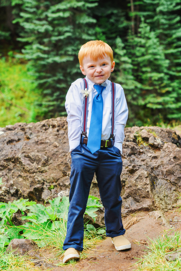 The little one was dressed in blue pants, a blue shirt and tie and red suspenders