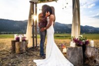 06 ranch wedding ceremony space with a wooden arch, burlap, greenery and flowers right in the field