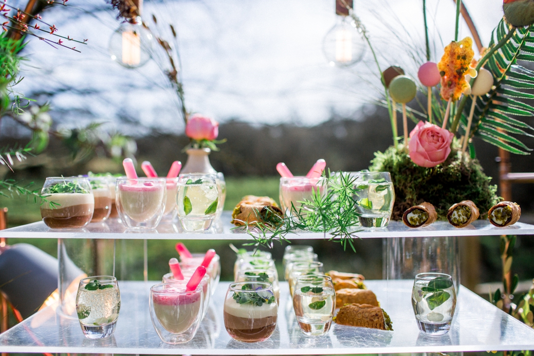Drinks and desserts served on a glass stand and a moss stand with macaron pops become a part of decor
