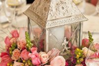 09 a whitewashed metal candle lantern on a pink floral arrangement for a shabby chic feel
