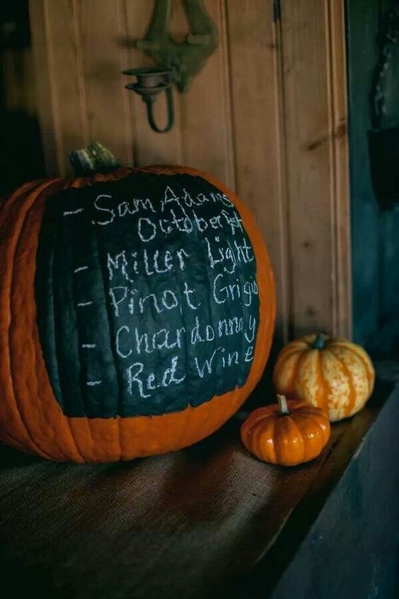 a large orange pumpkin covered with chalkboard paint and used for displaying a menu