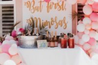 10 pink and peachy mimosa bar with lots of pink champagne bottles