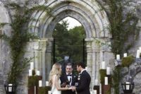 10 wedding ceremony in front of one of the Irish castles, a moody feel is achieved with a moss and candle backdrop