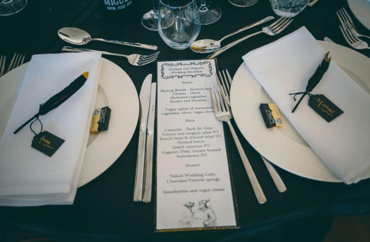 The wedding table setting was done in black and white, and each place setting was decorated with gold dipped black feathers