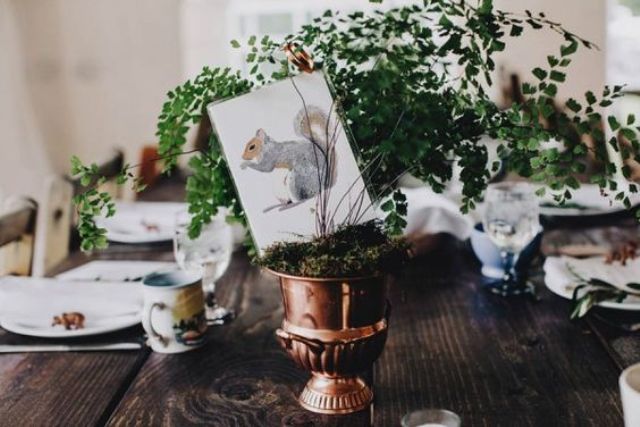 a copper urn with moss and greenery for a woodland wedding
