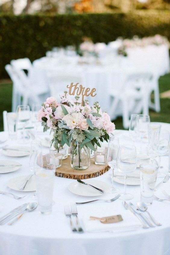 un simple décor de table blanche avec une tranche de bois et des cadets et une pièce maîtresse florale rose est facile à recréer