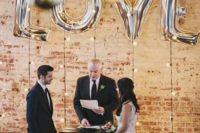 11 string lights and oversized LOVE balloons for an industrial wedding ceremony