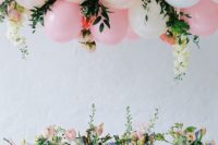12 a pink and cream balloon, flower and greenery garland hanging over the reception